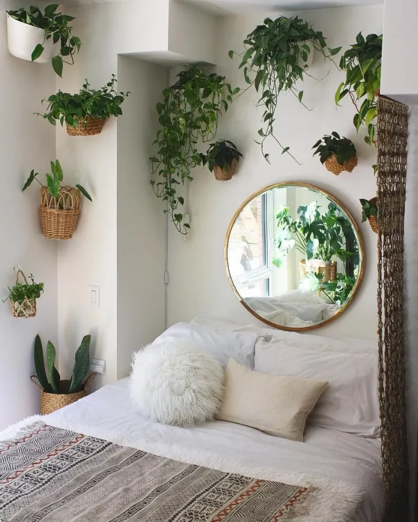 Mirror positioned in a small bedroom to reflect light and an open area of the room.